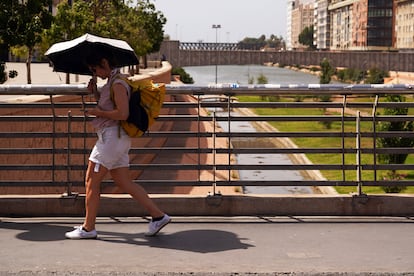 Una mujer camina protegida del sol en Málaga el pasado 1 de agosto. 