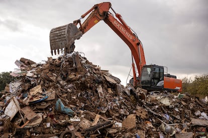 Una excavadora trabaja en la pila de escombros que los vecinos han retirado de sus casas, este jueves en Aldaia.

