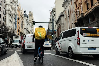 Un ciclista en Bicimad atascado entre el tráfico en la Gran Vía de Madrid. 