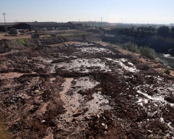 Zona de la cantera donde se ha vertido lodo retirado de los pueblos de la dana, a la derecha, una parte de la laguna.