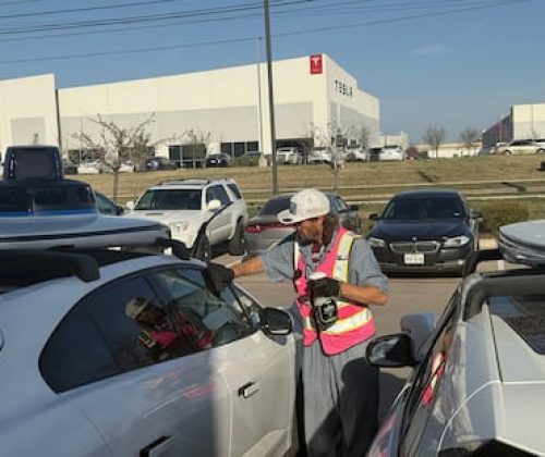 Un operario limpia un coche autónomo de Waymo en un almacén que tiene Uber y gestiona la empresa española Avomo en Austin, frente a un taller de Tesla.